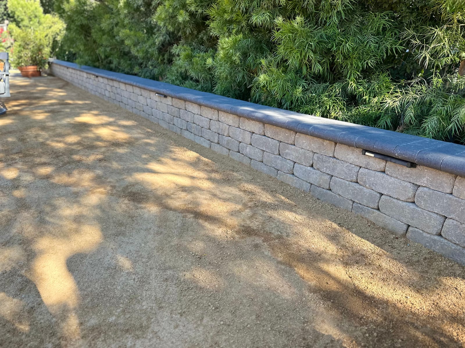 Segmental block retaining wall beside a paver driveway, built by Royal Outdoor Solutions in the Bay Area