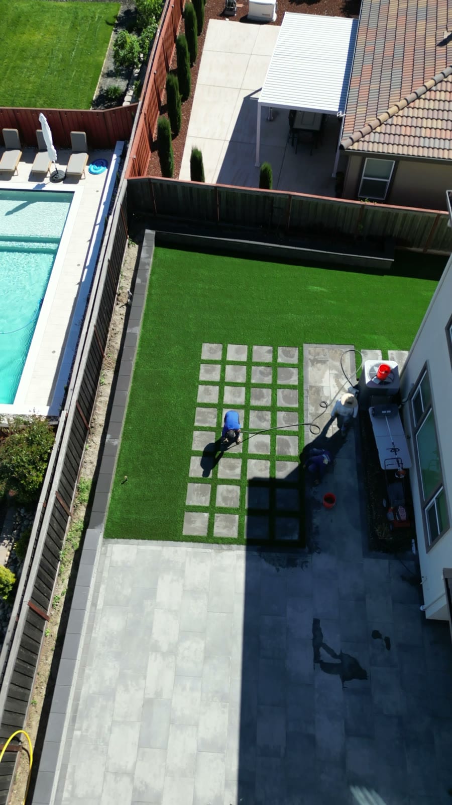 Side aerial view of paver patio and turf grid installation with pool in background, Fairfield, CA